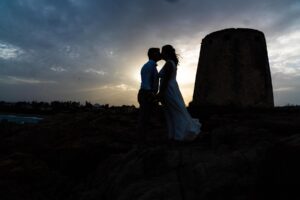 romantische Momente nach der Strandhochzeit, Kuss des Brautpaares neben Sarazenenturm - meer sardinien urlaub